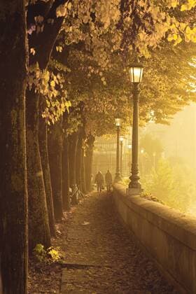 Italy, Verona, two people walking at riverbank of Adige in sunset  FCF01118