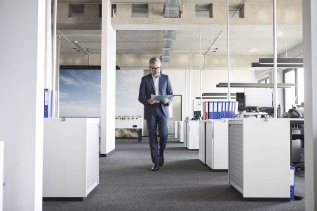 Businessman walking in office holding documents model released Symbolfoto property released  RBF05298