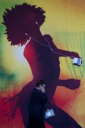 Sep 05, 2007 - San Francisco, CA, USA - Apple Revamps Entire iPod lineup and Announces Wi-Fi iTunes Store . PICTURED: An attendant at one of Apple s legendary product launches talks on his cell phone in front of a giant iPod poster. - ZUMAw49_ 20070905_sha_w49_977