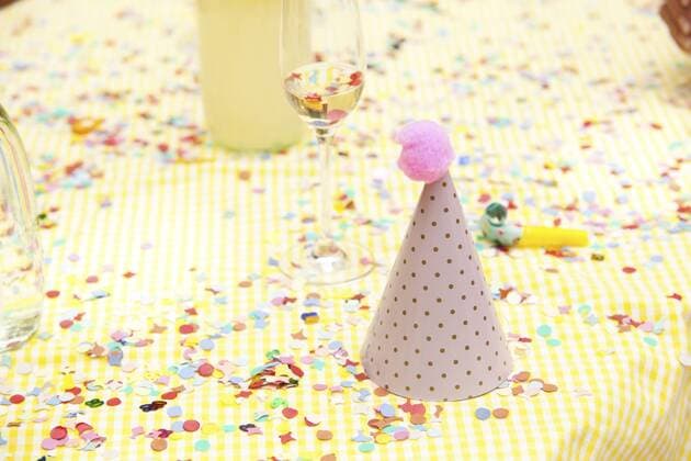 Party hat and party blower on table with confetti property released  MFRF00813