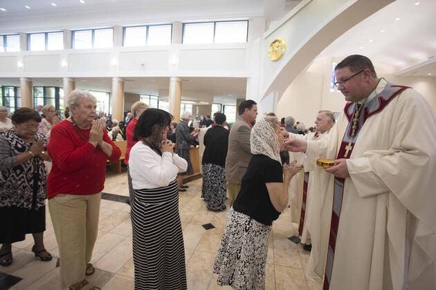 January 4, 2017 - St. Petersburg, Florida, U.S. - SCOTT KEELER Times. New Bishop Gregory L. Parkes, right, Diocese of St. Petersburg, offers the communion to parishioners, 1 4 16 at the Cathedral of St. Jude the Apostle during his installment. Parkes is the fifth Bishop in the Diocese. St. Petersburg U.S. - ZUMAs70_ 20170104_zan_s70_041