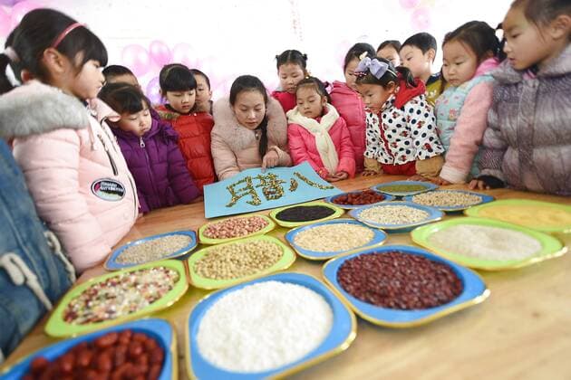 January 4, 2017 - Lianyungang, Lianyungang, China - Lianyungang, CHINA-January 4 2017: (EDITORIAL USE ONLY. CHINA OUT)..Pupils learn to recognize five kinds of cereals under the guidance of teacher at a primary school in Donghai County, Lianyungang City,east China s Jiangsu Province, January 4th, 2017, celebrating the Laba Rice Porridge Festival which falls on January 5th this year. The Laba Rice Porridge Festival is a traditional Chinese festival falls on the 8th day of the 12th month of lunar calendar. It s customary on this day to drink the special porridge, usually stewed of at least eight ingredients. With rice as the main ingredient, this porridge may well contain ingredients like broad beans, red beans, mung beans, red dates, peanuts, chest nuts, both tasty and nutritious. Lianyungang China - ZUMAs145 20170104_zaa_s145_188