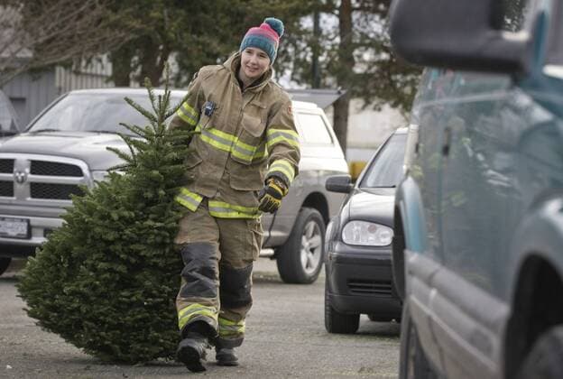 (170108) -- RICHMOND, Jan. 8, 2017 -- A firefighter carries a tree for recycling during the annual Christmas tree recycling in Richmond, Canada, Jan. 7, 2017. Firefighters volunteered their time to help residents recycle the Christmas trees at the annual Richmond Firefighters Association tree-chipping event to help reduce waste and turn rubbish into new resources.) (zxj) CANADA-RICHMOND-CHRISTMAS TREES-RECYCLING LiangxSen 