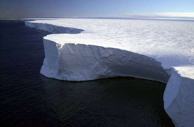 Dec 08, 2006 - Ross Sea, Antarctica - Research on Iceberg B-15A. The northern edge of the giant iceberg, B-15A, in the Ross Sea, Antarctica. Iceberg B-15A is a fragment of a much larger iceberg (B-15) that broke away from the Ross Ice Shelf in March 2000. Scientists believe that the enormous piece of ice broke away as part of a long-term natural cycle (every 50-to-100 years, or so) in which the shelf--which is roughly the size of Texas--sheds pieces much as human fingernails grow and break off. Researchers have placed global positioning systems (GPS), weather monitoring stations and four seismometers on different icebergs to track them. The goal is to learn more about what causes icebergs to calve, how and why they drift, what happens when the icebergs warm, and why they are producing previously unknown tremors that are picked up on seismometers as far away as Tahiti. Plans are to track - ZUMAz03_ 20061208_ptf_z03_458