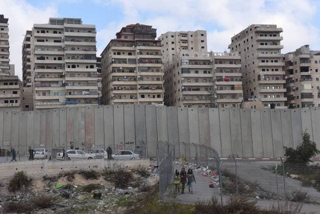 Palestinians walk through wire fences on a path that leads to a checkpoint in the Israeli separation wall that surrounds the Shurafat Refugee Camp northeast of Jerusalem, January 15, 2017. Representatives of 72 countries are meeting today in Paris for a one day Peace Summit in the latest bid to restart peace talks between Israel and the Palestinians. Israeli Prime Minister Benjamin Netanyahu says the Paris peace talks are useless while the Palestinians welcome the multinational approach to brings the two sides to the negotiating table.  JER2017011512 DEBBIExHILL