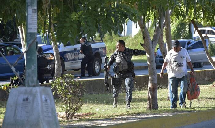 Members of the Armed Marines and state policemen face an armed group during a shooting targeted at public buildings in the central area of Cancun, Quintana Roo, Mexico, 17 January 2017. A public servant of Quintana Roo s Attorney s Office died in the attck. PUBLIC BUILDINGS ATTACKED IN CANCUN !ACHTUNG: NUR REDAKTIONELLE NUTZUNG!  MEX010 20170118-636202981441592491