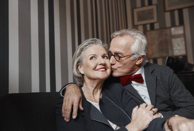 Senior man kissing wife on couch model released Symbolfoto property released  RHF01778