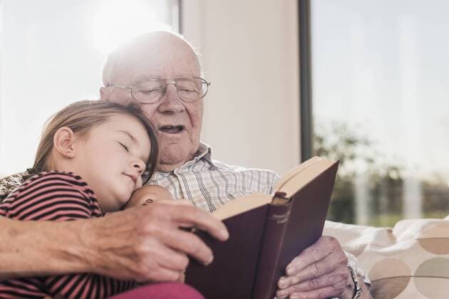 Grandfather reading out story for his granddaughter model released Symbolfoto property released  UUF09572
