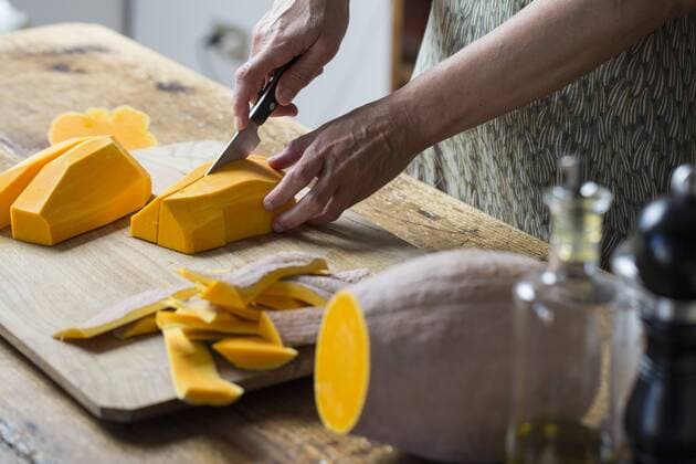 Woman chopping pumpkin for preparation of raw pumpkin noodles model released Symbolfoto  ALBF00064