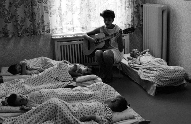 07.05.1983, Berlin, Deutsche Demokratische Republik (DDR) - Kindergaertnerin spielt vor dem Mittagsschlaf der Kinder auf der Gitarre. (QF, europäisch, Beschäftigung, Kindertagesstätte, Schlafplätze, Kindergärtnerin) 00S830507A001.JPG MODEL RELEASE: NO, PROPERTY RELEASE: NO MR:N