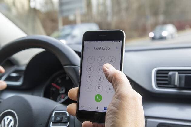 Mann, Autofahrer, benutzt ein Handy, während der Fahrt, wählt Telefonnummer, ohne Freisprecheinrichtung,