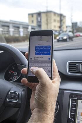 Mann, Autofahrer, benutzt ein Handy, während der Fahrt, SMS schreiben,