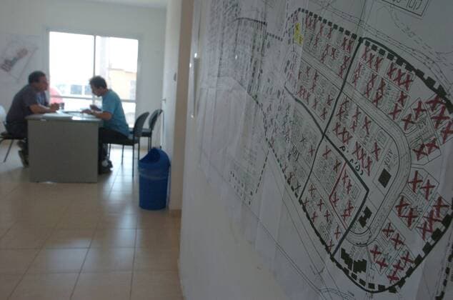 Aug 15, 2005; Nitzan, ISRAEL; Directors of the temporary housing development discuss the relocation of settlers, a development map is seen on the wall tot the right. Temporary housing development for relocated settlers from Gush Katif in Gaza Strip. The development consists of over 300 homes and is currently occupied by 180 families with many waiting on lists to sign contracts in order to move in. Mandatory - ZUMAb09_ 20050815_mdm_b09_569 Copyright: xBryanxSmithx