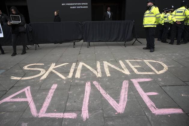 London Fashion Week: Animalist Protest Animalist protest against the use of fur and skin, outside 180 Strand, the principal location of London Fashion Week. Protester hold placard with images of skinned animals and masks.  AlbertoxPezzali