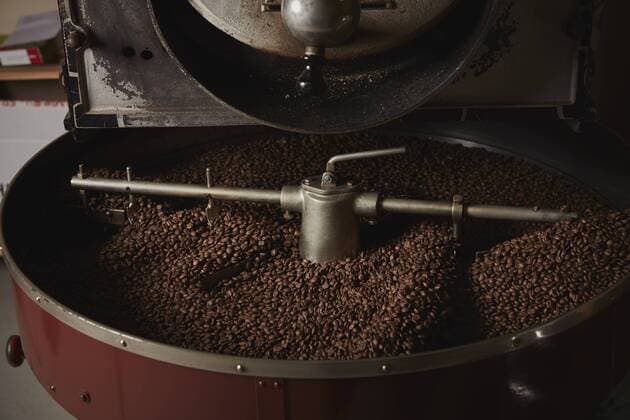 A coffee shop. A metal drum with roasting coffee beans and a central paddle. A coffee shop. A metal drum with roasting coffee beans and a central paddle.  27267