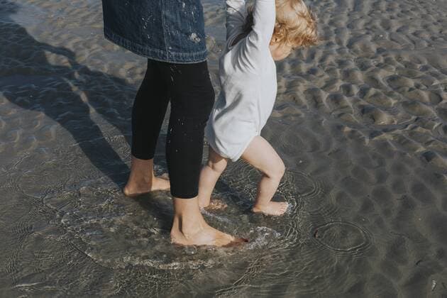 Mother with little daughter wading in water on the beach model released Symbolfoto  DWF00266