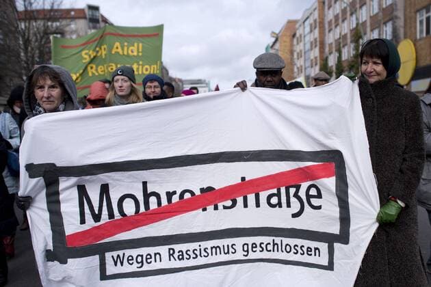 Gedenkmarsch Kolonialgeschichte DEU, Deutschland, Germany, Berlin, 25.02.2017 Demonstranten mit Transparent Mohrenstrasse wegen Rassismus geschlossen fuer die Umbennenung von Strassennamen beim 11. Gedenkmarsch zur Erinnerung an die afrikanischen Opfer von Versklavung, Kolonialismus und rassistischer Gewalt vom Komitee fuer ein afrikanisches Denkmal in Berlin und afrikanischer Vereine in Berlin. Dieser Gedenkmarsch wurde ins Leben gerufen, um der Forderung nach Anerkennung der Verbrechen gegen Schwarze Menschen und Menschen afrikanischer Herkunft Nachdruck zu verleihen. Anlass ist die Berliner Afrika-Konferenz von 1884 - 1885, auf der Afrika vor 130 Jahren unter den europaeischen Kolonialmaechten aufgeteilt wurde. Mehr als 30 Millionen Afrikanerinnen und Afrikaner wurden Opfer von Versklavung und kolonialen Verbrechen gegen die Menschlichkeit. Die von Deutschland an den Herero und Nama b