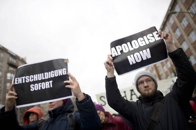 Gedenkmarsch Kolonialgeschichte DEU, Deutschland, Germany, Berlin, 25.02.2017 Demonstranten mit Plakat Apologise now, Entschuldigung sofort, beim 11. Gedenkmarsch zur Erinnerung an die afrikanischen Opfer von Versklavung, Kolonialismus und rassistischer Gewalt vom Komitee fuer ein afrikanisches Denkmal in Berlin und afrikanischer Vereine in Berlin. Dieser Gedenkmarsch wurde ins Leben gerufen, um der Forderung nach Anerkennung der Verbrechen gegen Schwarze Menschen und Menschen afrikanischer Herkunft Nachdruck zu verleihen. Anlass ist die Berliner Afrika-Konferenz von 1884 - 1885, auf der Afrika vor 130 Jahren unter den europaeischen Kolonialmaechten aufgeteilt wurde. Mehr als 30 Millionen Afrikanerinnen und Afrikaner wurden Opfer von Versklavung und kolonialen Verbrechen gegen die Menschlichkeit. Die von Deutschland an den Herero und Nama begangenen Voelkermorde in Namibia und die Kriegs