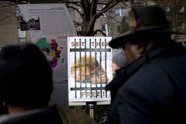 Gedenkmarsch Kolonialgeschichte DEU, Deutschland, Germany, Berlin, 25.02.2017 Demonstranten mit Plakat Set Them Free fordert die Rueckgabe von Totenschaedel nach Namibia beim 11. Gedenkmarsch zur Erinnerung an die afrikanischen Opfer von Versklavung, Kolonialismus und rassistischer Gewalt vom Komitee fuer ein afrikanisches Denkmal in Berlin und afrikanischer Vereine in Berlin. Dieser Gedenkmarsch wurde ins Leben gerufen, um der Forderung nach Anerkennung der Verbrechen gegen Schwarze Menschen und Menschen afrikanischer Herkunft Nachdruck zu verleihen. Anlass ist die Berliner Afrika-Konferenz von 1884 - 1885, auf der Afrika vor 130 Jahren unter den europaeischen Kolonialmaechten aufgeteilt wurde. Mehr als 30 Millionen Afrikanerinnen und Afrikaner wurden Opfer von Versklavung und kolonialen Verbrechen gegen die Menschlichkeit. Die von Deutschland an den Herero und Nama begangenen Voelkermo
