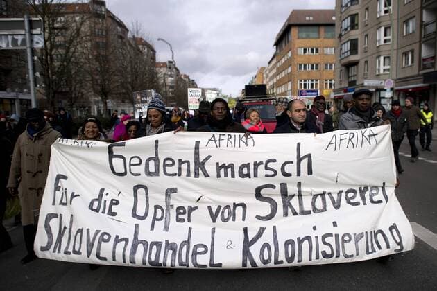Bilder des Tages Gedenkmarsch Kolonialgeschichte DEU, Deutschland, Germany, Berlin, 25.02.2017 Demonstranten mit Transparent beim 11. Gedenkmarsch zur Erinnerung an die afrikanischen Opfer von Versklavung, Kolonialismus und rassistischer Gewalt vom Komitee fuer ein afrikanisches Denkmal in Berlin und afrikanischer Vereine in Berlin. Dieser Gedenkmarsch wurde ins Leben gerufen, um der Forderung nach Anerkennung der Verbrechen gegen Schwarze Menschen und Menschen afrikanischer Herkunft Nachdruck zu verleihen. Anlass ist die Berliner Afrika-Konferenz von 1884 - 1885, auf der Afrika vor 130 Jahren unter den europaeischen Kolonialmaechten aufgeteilt wurde. Mehr als 30 Millionen Afrikanerinnen und Afrikaner wurden Opfer von Versklavung und kolonialen Verbrechen gegen die Menschlichkeit. Die von Deutschland an den Herero und Nama begangenen Voelkermorde in Namibia und die Kriegsverbrechen in Tansania im Maji- M