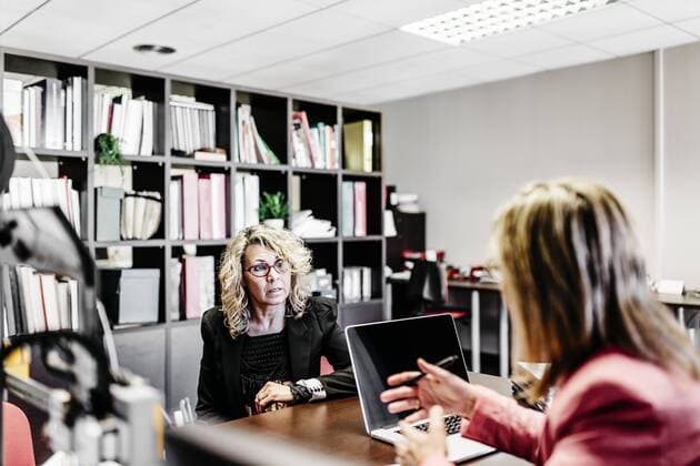 Two businesswomen talking at desk in office model released Symbolfoto property released  JRFF01182