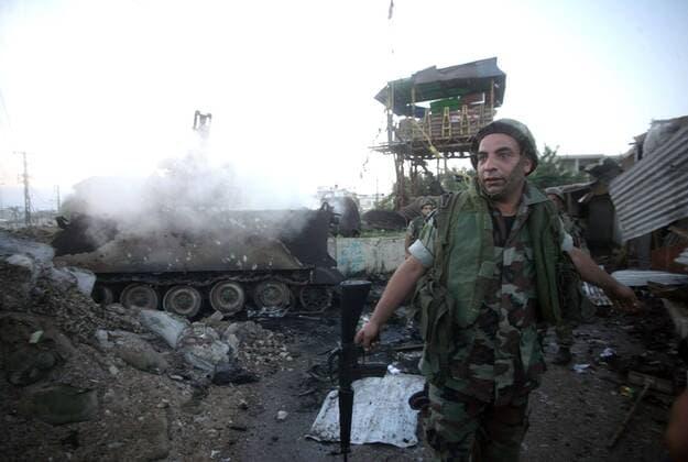 Aug. 4, 2006 - U.S. - A Lebanese soldier stands in front of an army vehicle still smoking from an Israeli air strike on the army position in the town of Tyre, in southern Lebanon, on Saturday August 5, 2006. The Lebanese army has been hit several times by Israeli forces battling Hezbollah guerrillas but has rarely fought back, and many question whether the weak army will be able to keep Hezbollah from firing rockets at Israel, as a Lebanese government plan has suggested. ( MCT) - ZUMAm67_ 20060804_baf_m67_017 Copyright: xPaulxAssakerx