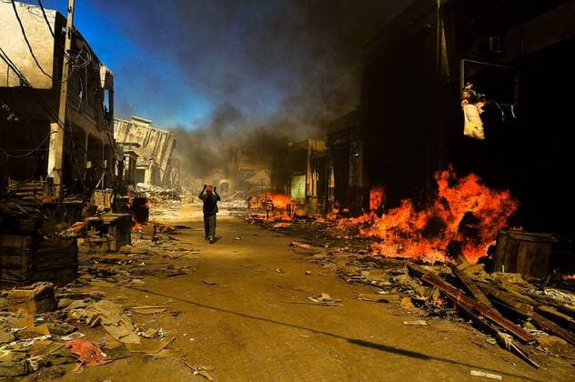 Jan 29, 2010 - Port-au-Prince, Haiti - The eruption of violence and looting when the hungry, desperate and frustrated people of Haiti, unassisted by their country s leaders or helped by the international community, decided to find their own means of survival in the badly damaged capital Port-au-Prince after the 7.0 quake in which more then 230,000 people died. PICTURED - Boy walks down middle of street in between fires in Port-au-Prince. - ZUMAl88_ 20100129_clb_l88_207 Copyright: xAndrexLiohnx