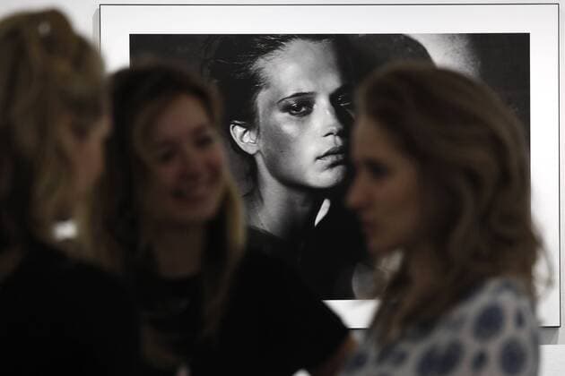 MOSCOW, RUSSIA - MARCH 16, 2017: Visitors by a photograph of actress Alicia Vikander taken for the 2017 Pirelli Calendar on display at an exhibition titled Pirelli Calendar 2017 by Peter Lindbergh at Moscow s Multimedia Art Museum. The exhibition is open from March 17 to May 14, 2017. Artyom Geodakyan TASS  TS044860