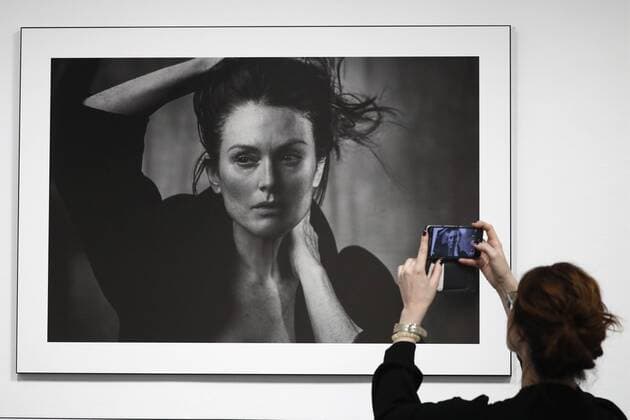 MOSCOW, RUSSIA - MARCH 16, 2017: A woman takes a picture of a photograph of actress Julianne Moore taken for the 2017 Pirelli Calendar on display at an exhibition titled Pirelli Calendar 2017 by Peter Lindbergh at Moscow s Multimedia Art Museum. The exhibition is open from March 17 to May 14, 2017. Artyom Geodakyan TASS  TS04486C