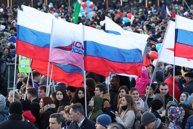 MOSCOW, RUSSIA - MARCH 18, 2017: People carry Russian national flags at a concert marking the 3rd anniversary of Crimea s reunification with Russia, by the Moscow State University main building. Vyacheslav Prokofyev TASS  TS044BF3