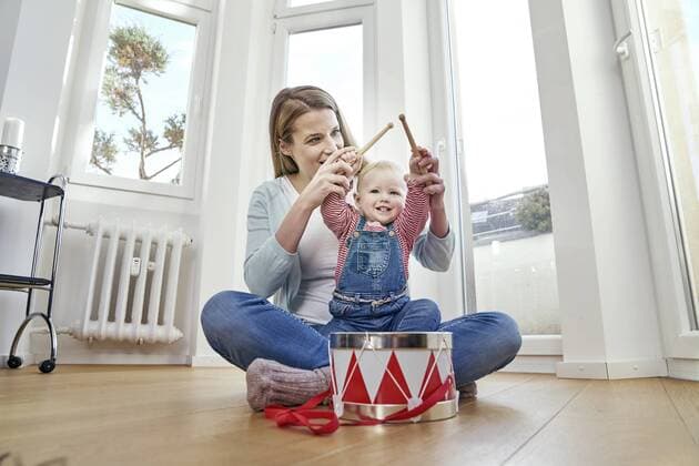 Mother and baby girl sitting on floor playing drums model released Symbolfoto property released  FMKF03600