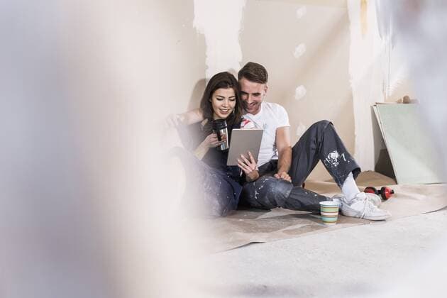 Young couple on construction site of their new home, using digital tablet model released Symbolfoto property released  UUF10106