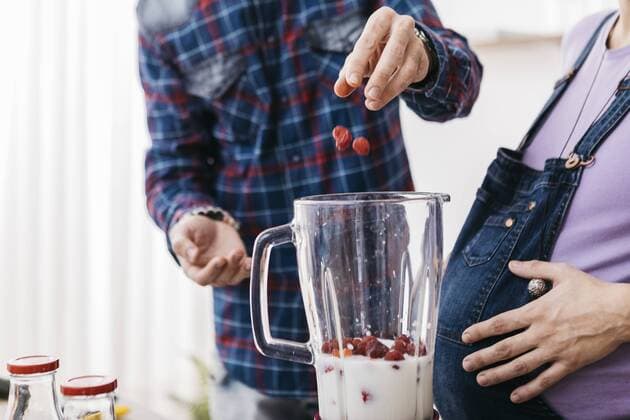 Couple preparing smoothie with raspberries, partial view model released Symbolfoto property released  JRFF01214