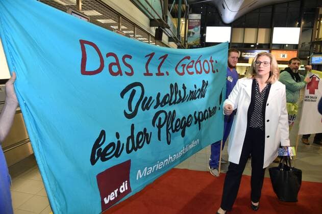 Aufstehen für die Pflege - und das in aller Frühe. Beschäftigte der Pflegeberufe demonstrieren am Montagmorgen (27.3.2017) im Terminal des Flughafen Saarbrücken und nutzen ihre Chance, die Spitzenkandidaten der Landtagswahl auf dem Weg zur Berlin-Maschine abzufangen. Hier Wirtschaftsministerin Anke Rehlinger von der SPD.