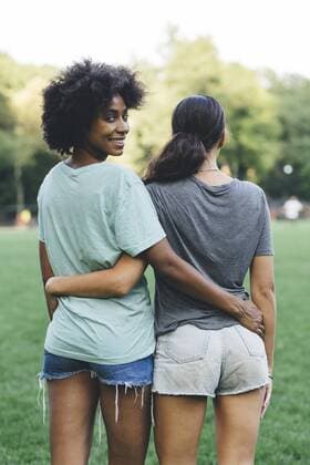 Two women arm in arm in a park model released Symbolfoto  GIOF01980