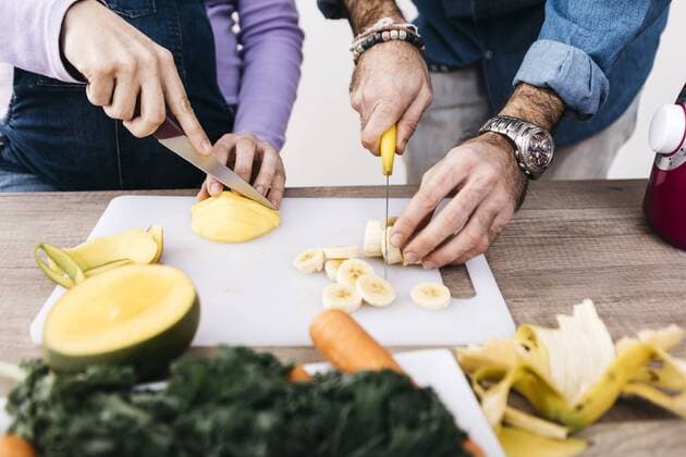 Hands of couple chopping fruits for preparing smoothies model released Symbolfoto property released  JRFF01238