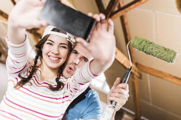Young couple renovating their new home, taking smart phone selfies model released Symbolfoto property released  UUF10143