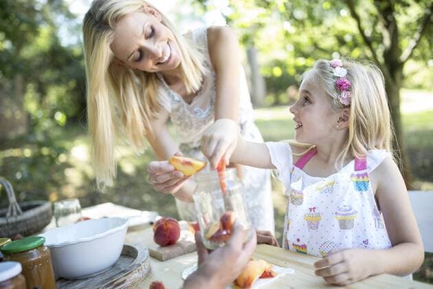 Smiling mother and daughter preserving peaches model released Symbolfoto  WESTF22802
