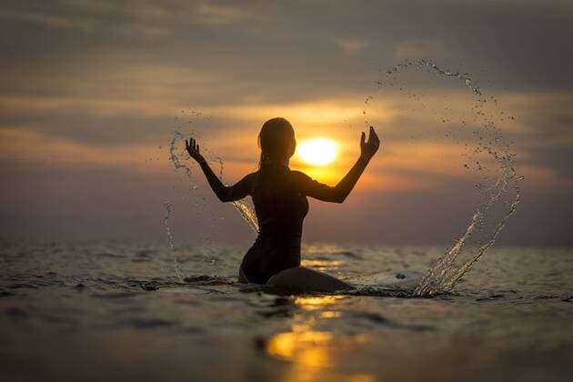 Indonesia, Bali, female surfer in the ocean at sunset model released Symbolfoto  KNTF00637