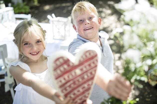 Smiling sister and brother holding heart and bunch of flowers model released Symbolfoto  WESTF22799