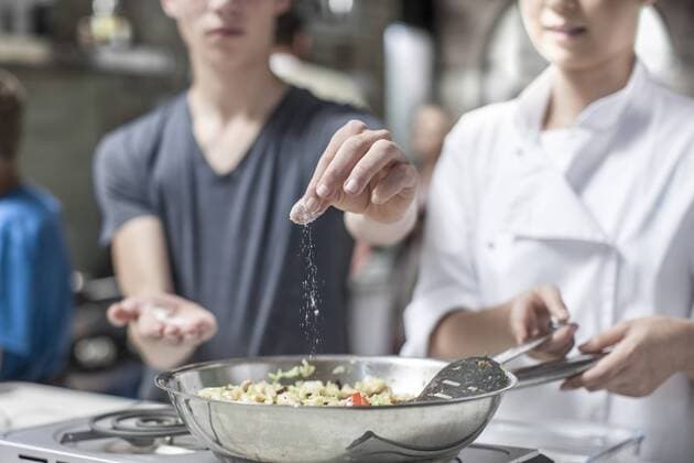 Teenager adding salt to pan model released Symbolfoto property released  ZEF13544