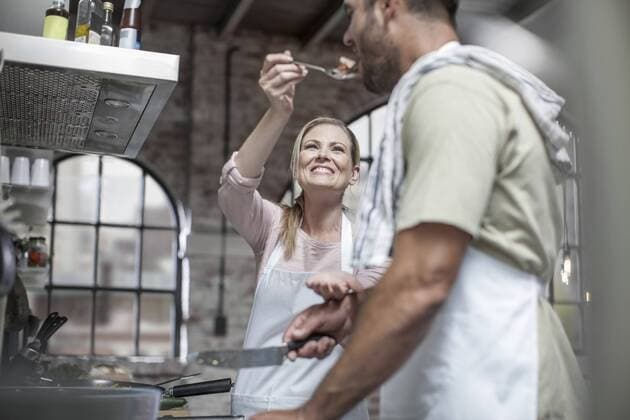 Couple cooking together and tasting food in kitchen model released Symbolfoto property released  ZEF13558