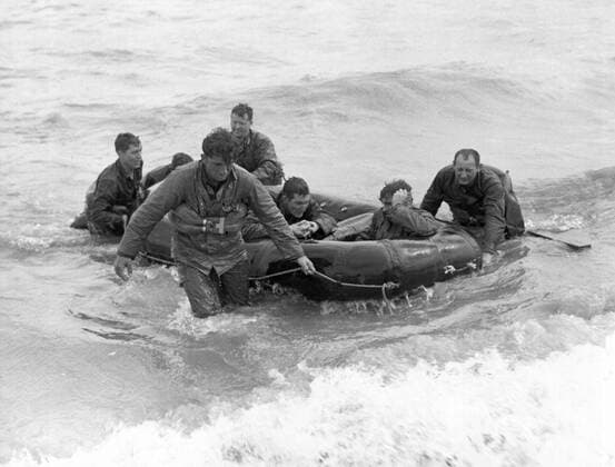 Normandy, France: June 6, 1944 Survivors of a sunk LCVP off the coast of France come safely ashore at Omaha Beach in a rubber life raft. xUnderwoodxArchives 4-WWII-US-E-DDay_10 4-WWII-US-E-DDay_10HR
