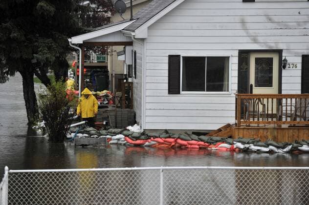 (170506) -- GATINEAU, May 6, 2017 -- A man stands in front of a house in flooded Gatineau, Quebec province of Canada, May 5, 2017. Several areas across Quebec is flooded as heavy rain has continued for days in eastern Canada. ) (zxj) CANADA-GATINEAU-FLOOD KADRIxMohamed 