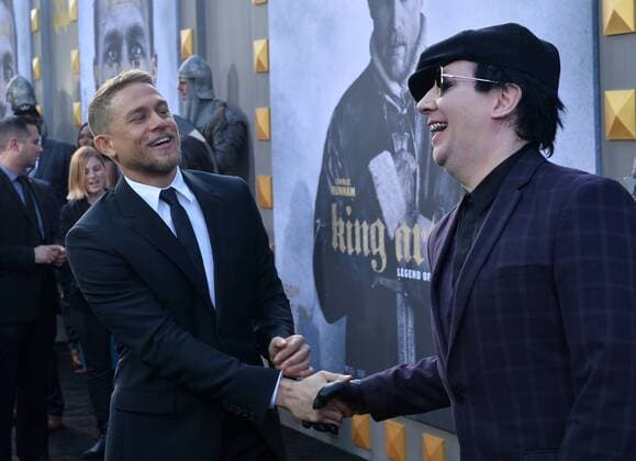 Cast member Charlie Hunnam (L) greets musician Marilyn Manson during the premiere of the motion picture fantasy King Arthur: Legend of the Sword at TCL Chinese Theatre in the Hollywood section of Los Angeles on May 8, 2017. Storyline: Robbed of his birthright, Arthur comes up the hard way in the back alleys of the city. But once he pulls the sword from the stone, he is forced to acknowledge his true legacy - whether he likes it or not.  LAP20170508925 JIMxRUYMEN