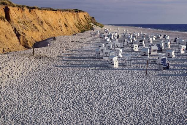 Strand und Strandkoerbe am Roten Kliff am Abend, Deutschland, Schleswig-Holstein, Sylt, Kampen roofed wicker beach chairs at the sandy beach of Rotes Kliff in evening light, Germany, Schleswig-Holstein, Sylt, Kampen BLWS452727 Copyright: xblickwinkel McPHOTO I.xSchulzx
