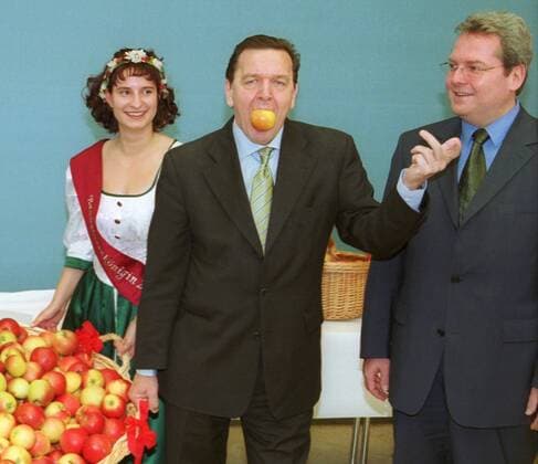 Mit einem Apfel im Mund begruesst Bundeskanzler Gerhard Schroeder (SPD) die wartenden Journalisten vor Beginn der 88. Kabinettssitzung im Bundeskanzleramt (r, Rolf Schwanitz (SPD, MdB), Beauftragter der Bundesregierung fuer Angelegenheiten der neuen Laender). Die Aepfel wurden von Bundeslandwirtschaftsminister Karl-Heinz Funke (SPD) an alle Kabinettsmitglieder verteilt, Berlin den 13.12.2000, Berlin Deutschland Copyright: xThomasxKoehlerx