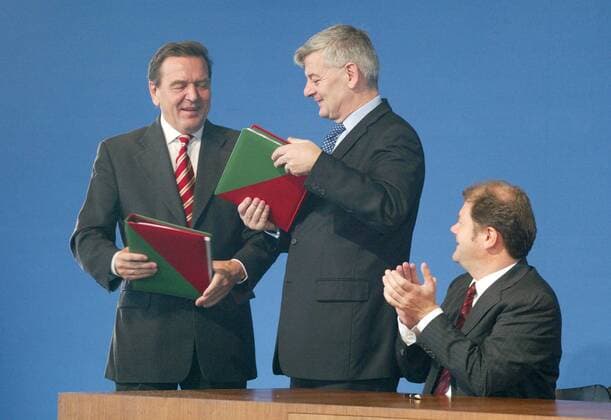 Unterschrift unter die Koalitionsvereinbarung zwischen SPD und Gruene : Bundeskanzler Gerhard Schroeder (l), SPD, und Bundesaussenminister Joschka Fischer, Gruene. Es applaudiert Olaf Scholz, designierter SPD Generalsekretaer. Berlin, 16.10.2002, Berlin Deutschland Copyright: xThomasxKoehlerx