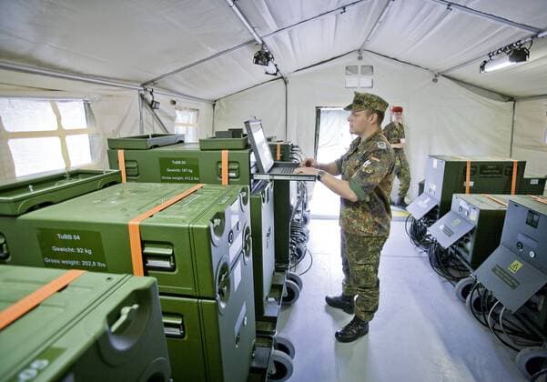 Soldat der Bundeswehr bedient einen Laptop in einem mobilen Rechenzentrum ( Mobiles Kommunikations- und Informationsmodul ) und in einem Feldlager auf dem Truppenuebungsplatz Luebtheen . Mit diesem Rechenzentrum ist es moeglich , auch verschluesselte Nachrichten aus dem Einsatzgebiet an die Einsatzleitung zu uebertragen . Luebtheen , Deutschland . Soldier of german armed forces in a Deployable Communication and Information System Modul at a military training area in Luebtheen . Luebtheen , Germany . 26.05.2009 , , , Luebtheen DEU Deutschland Copyright: xThomasxTrutschelx