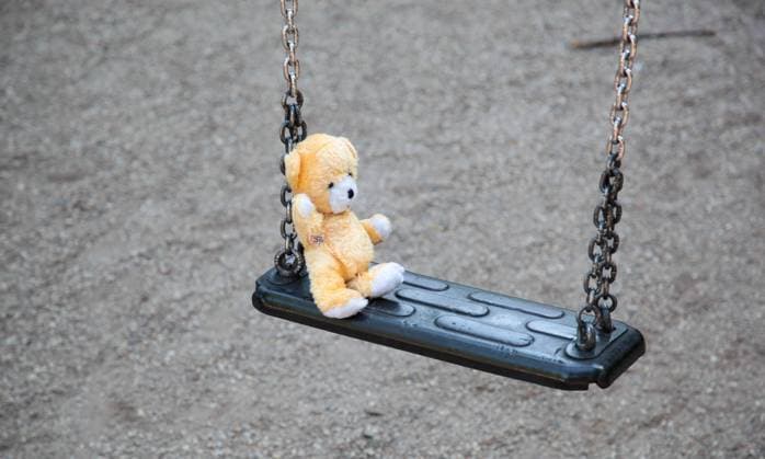 Tatort Spielplatz. Ein Plüschbär auf einer Schaukel Verbrechen